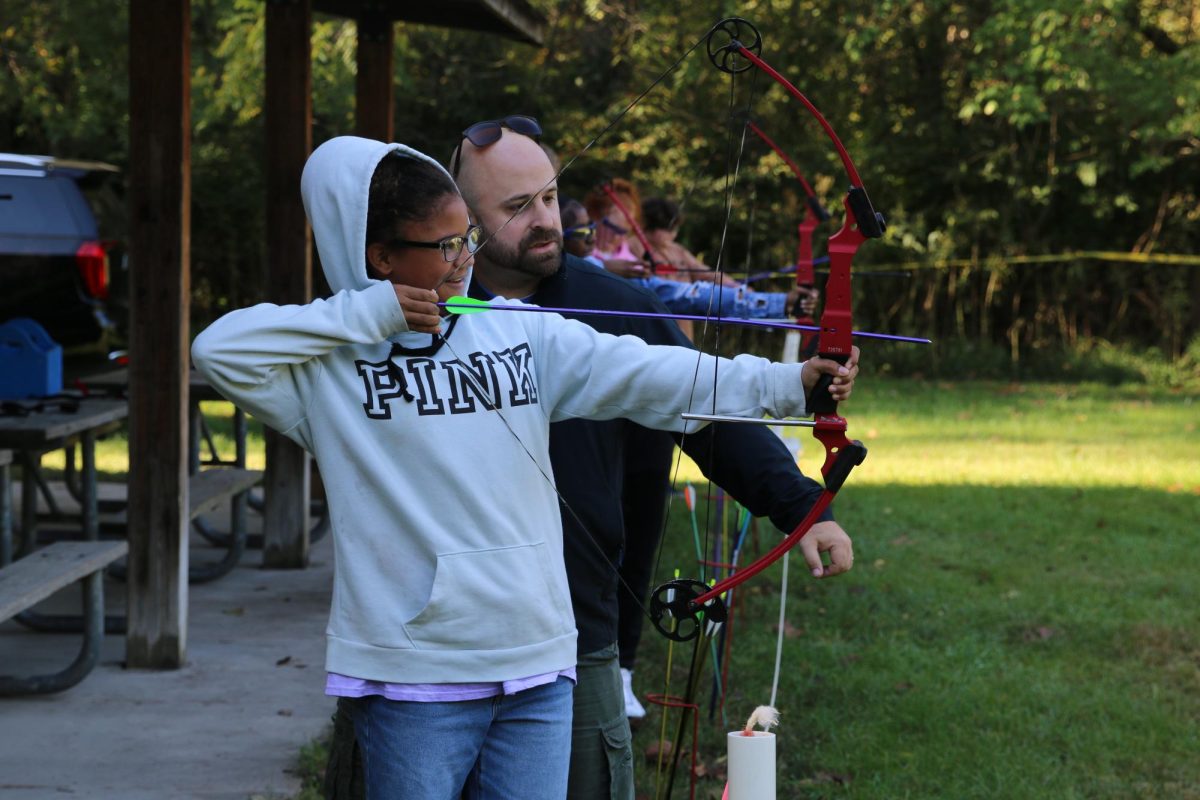 Freshman Precious Silver lines up her shot at the archery station under the guidance of Mr. Ryan Kirchner.  